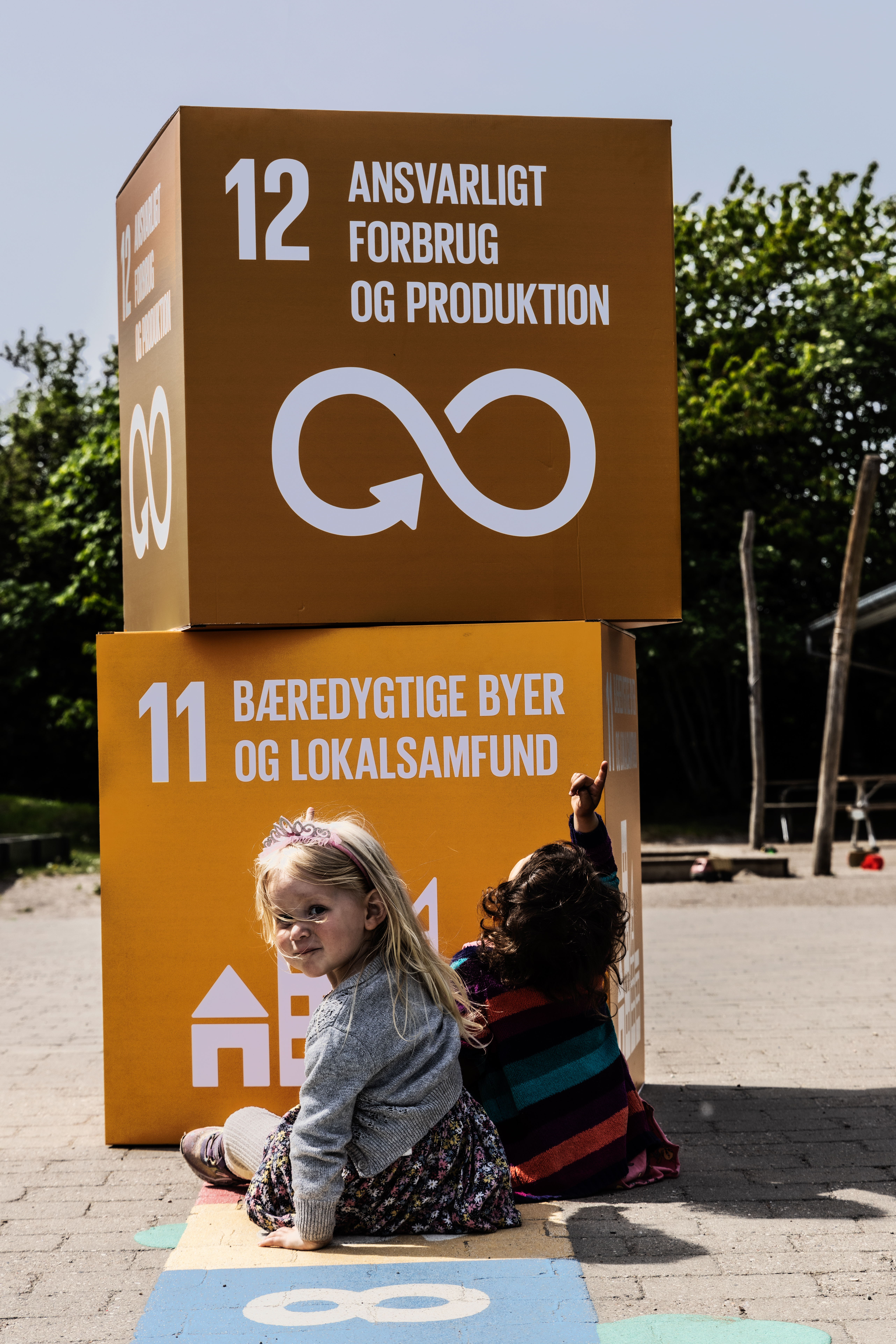 Børn peger på kasser med verdensmålene